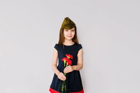 Cute little girl with flowers on May 9, Victory Day in Russia.