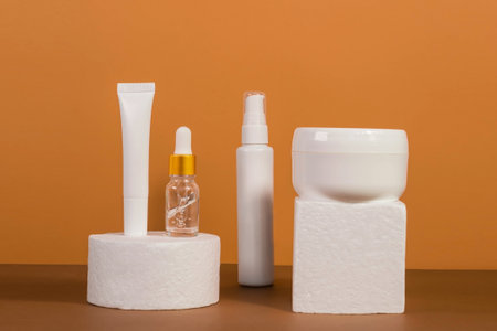 Copy space geometric shapes with night, day cream cosmetic oil, eye cream on yellow background. Unbranded bottles in mockup style. Beauty background with facial cosmetic products. Spa, beauty concept.の写真素材