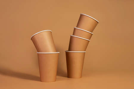 Paper disposable eco-friendly cups on beige isolated background. Eco-concept.の写真素材