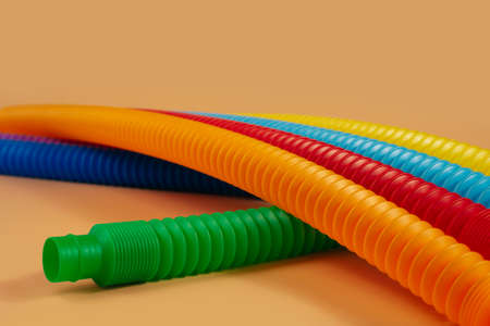 Group of multicolored rainbow toy pop it tube lying on beige background, trend toy for the development of fine motor skills of hands, anti stress crackling tubeの写真素材