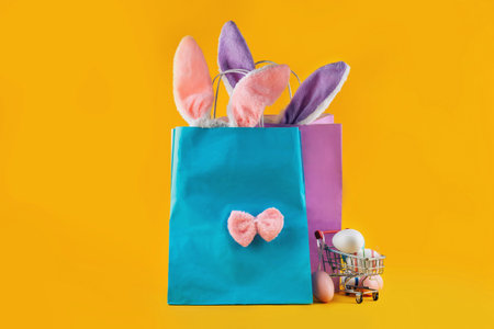 Very peri, blue shopping bag, rabbit ears and Easter eggs. Online shopping for the holidays. Symbols, traditions concept. Trending color of the year for Easterの写真素材