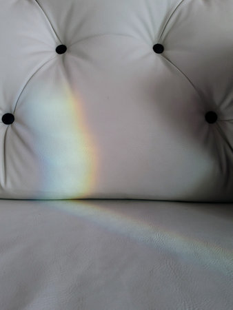 white leather sofa with rainbow in the room, closeup of photoの写真素材