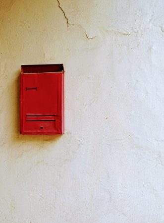 Red mailbox on a white wall, waiting for the letter to comeの写真素材