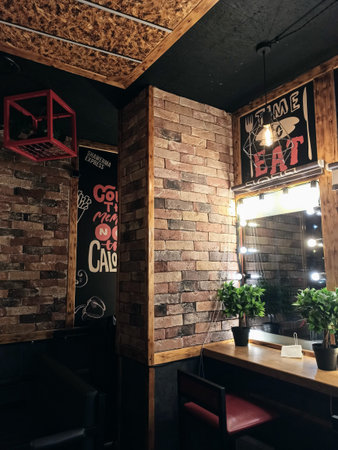 Interior of a cafe with brick walls and wooden tables with chairsの写真素材