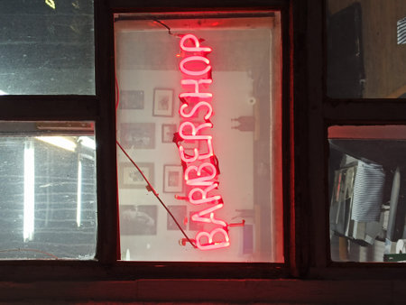 Neon sign on the window of a building with red letters.