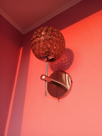 Vintage lamp hanging on the wall in a room with red wall