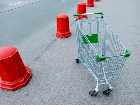Empty shopping cart on the road with red traffic cones in the backgroundの写真素材