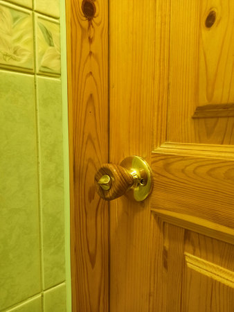 Wooden door with handle in the bathroom, closeup of photoの写真素材