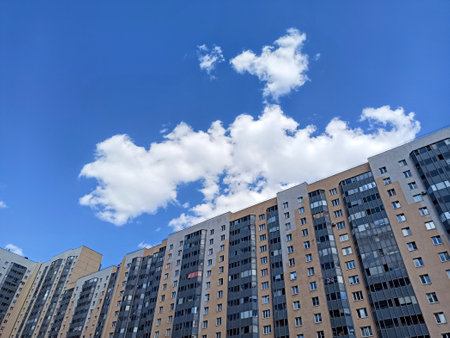Modern apartment buildings on a background of blue sky with white clouds.の写真素材