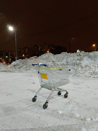 Shopping cart in the snow at night in the city