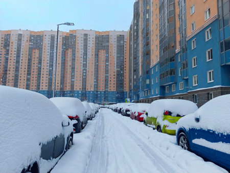 Cars covered in snow on a residential street during winterの写真素材