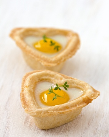 tartlets with egg on a wooden boardの写真素材