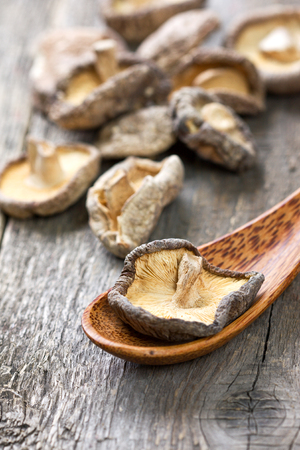 dried shiitake in a bowl on a woodenの写真素材