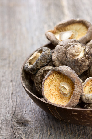 dried shiitake in a bowl on a woodenの写真素材