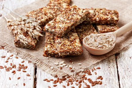 cereal bars, oatmeal, flax seeds on a wooden backgroundの写真素材