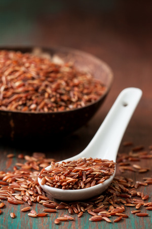 The spoon with red rice,  bowl with rice on a wooden background. Selective focusの写真素材