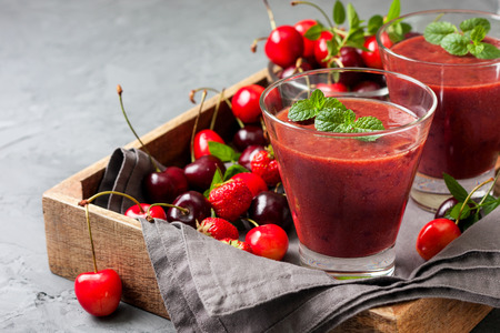 smoothie with cherry  in a glass, a mixture of sweet cherries on concrete backgroundの写真素材