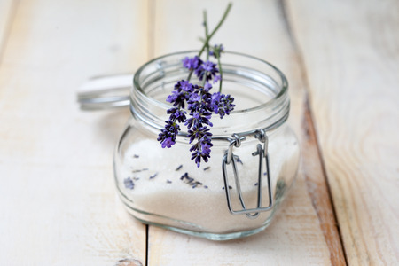 small bouquet of lavender on a jar of lavender sugar on a light wooden backgroundの写真素材