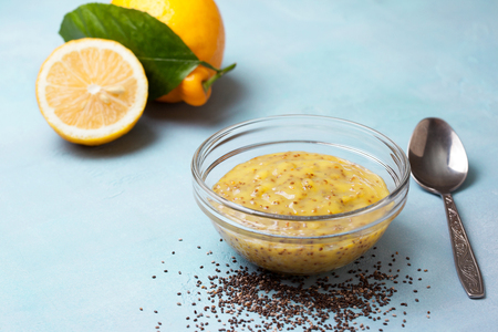 lemon curd chia pudding in a glass bowl,, fresh lemons on a blue backgroundの写真素材