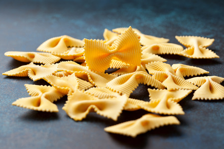 Traditional italian pasta farfalle on a blue background close-upの写真素材