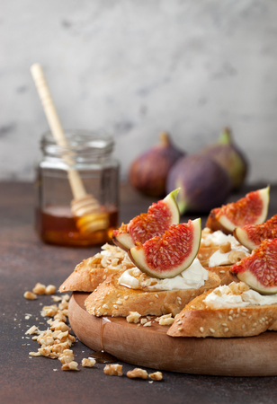 sandwiches with figs, ricotta, honey and walnuts on a brown backgroundの写真素材