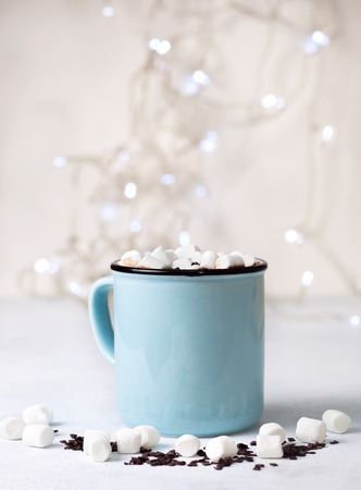 hot chocolate with marshmallow in a blue mug on a light background close-upの写真素材