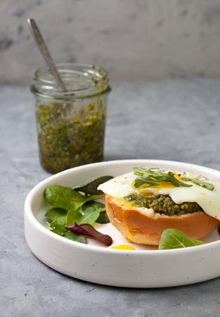 sandwich with pesto, egg in a white plate on a gray concrete backgroundの写真素材
