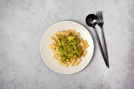 Pasta fuzullini with creamy spinach sauce and chicken on a gray stone background. view from aboveの写真素材