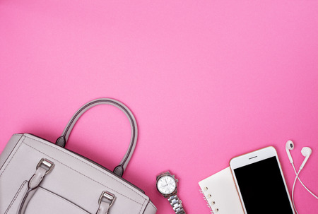 Gray women bag and smartphone, notebook, watch on a pinkの写真素材