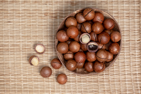 Macadamia nuts in the bowl on straw (bamboo)の写真素材