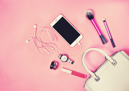 Women bag, smartphone, cosmetics, watches on a pinkの写真素材