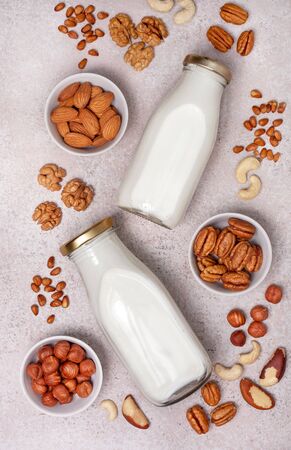 Vegan milk from nuts, different kinds of nuts on a lightの写真素材