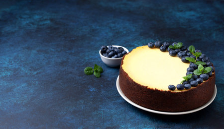 Lemon cheesecake with blueberries on a blue  close-upの写真素材