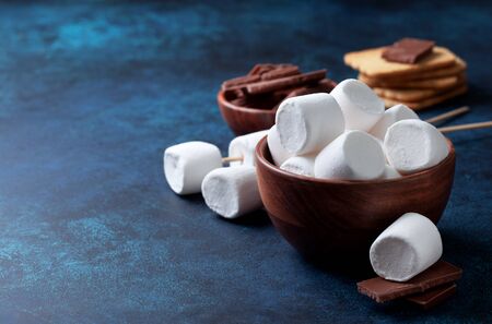 Marshmallows, chocolate and cookies for making smore on blueの写真素材