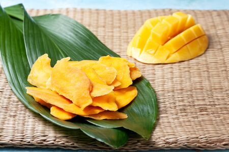 Pieces of dried mango, fresh mango on a strawの写真素材