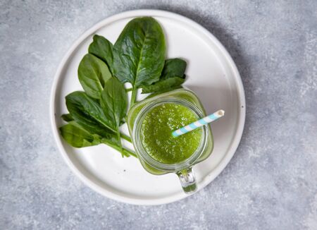 smoothie spinach in a mason jar, fresh spinach on a gray concrete background. view from above.の写真素材