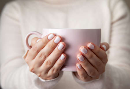 female hands holding a ceramic mugの写真素材
