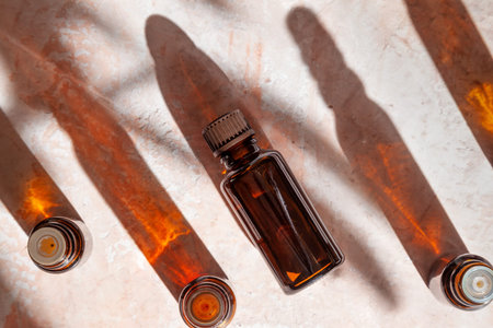 bottles with essential oil on a stone background with shadows. view from above.の写真素材
