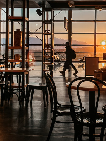 A stunning sunset view from a cafe featuring a person walking in silhouette. Perfect for travel themes.の写真素材