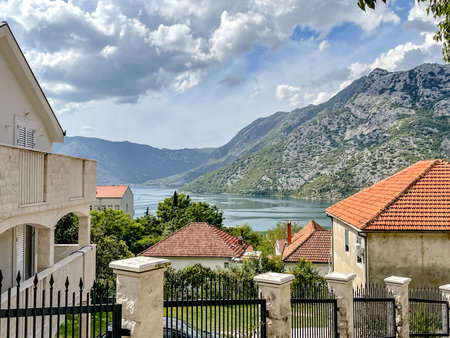 A breathtakingly stunning landscape featuring a serene bay and magnificent mountains beneath a...