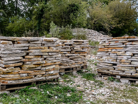 A serene and picturesque view of stacked stones and wooden pallets, all beautifully surrounded by vibrant greeneryの写真素材