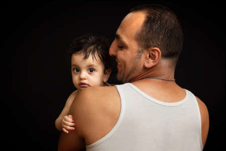 Happy father with his little daughter smiling. Studio portrait on black backgroundの写真素材