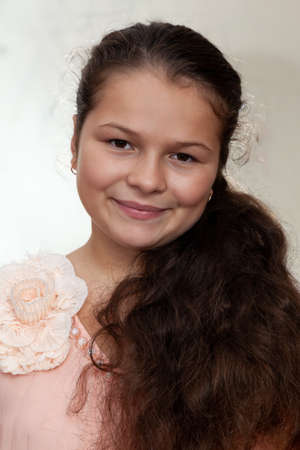 Portrait of a teenage girl with long curly hair on a white backgroundの写真素材