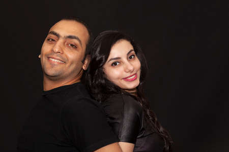 Family portrait of a young couple on a black background. Studio Portraitの写真素材