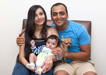 Studio portrait of a young family with a dog on a white background. High quality photoの写真素材