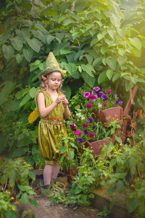 Portrait of a cute cute girl in a green gnome hat with a flower