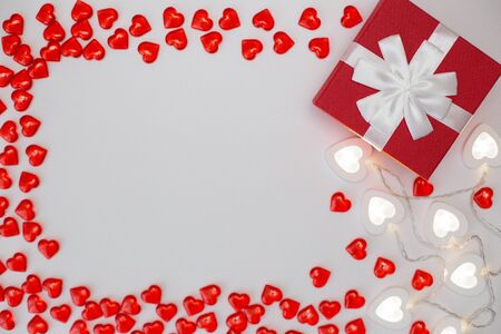 Red gift box , bright white heart-shaped garlands on a white background.の写真素材