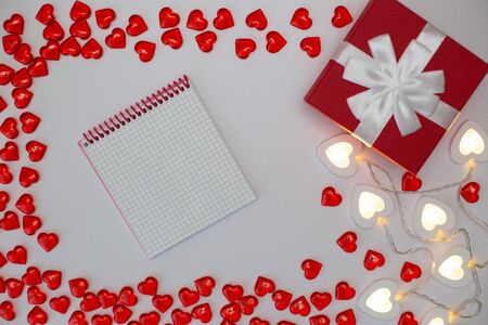 Red gift box , bright white heart-shaped garlands on a white background.の写真素材