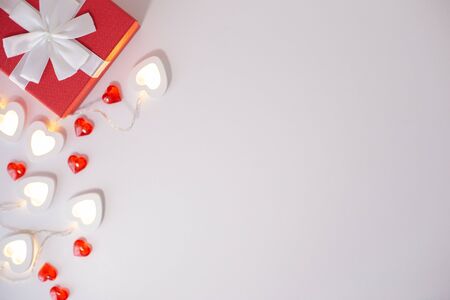 Red gift box , bright white heart-shaped garlands on a whiteの写真素材