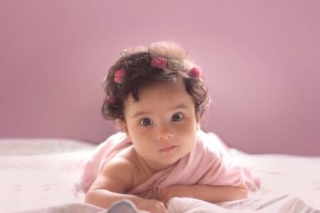 Beautiful little baby girl on a pink backgroundの写真素材